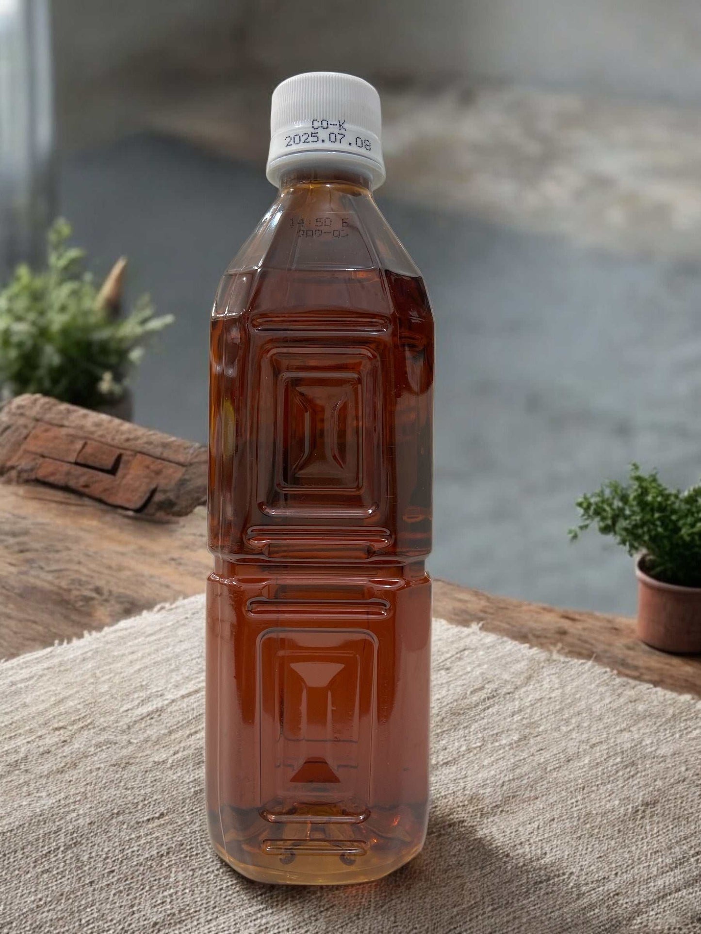 500ml plastic bottle of label-less black oolong tea by Life Drink Company set on a table
