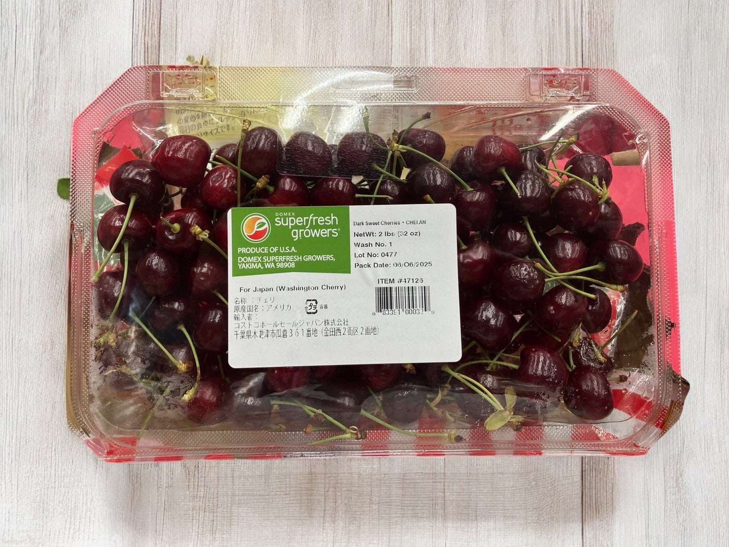 Packaging of fresh 900g USA cherries rich in vitamin C with stems on wooden surface
