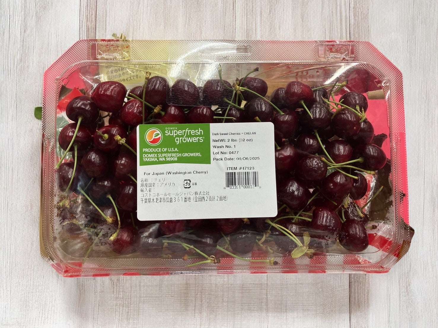 Packaging of fresh 900g USA cherries rich in vitamin C with stems on wooden surface