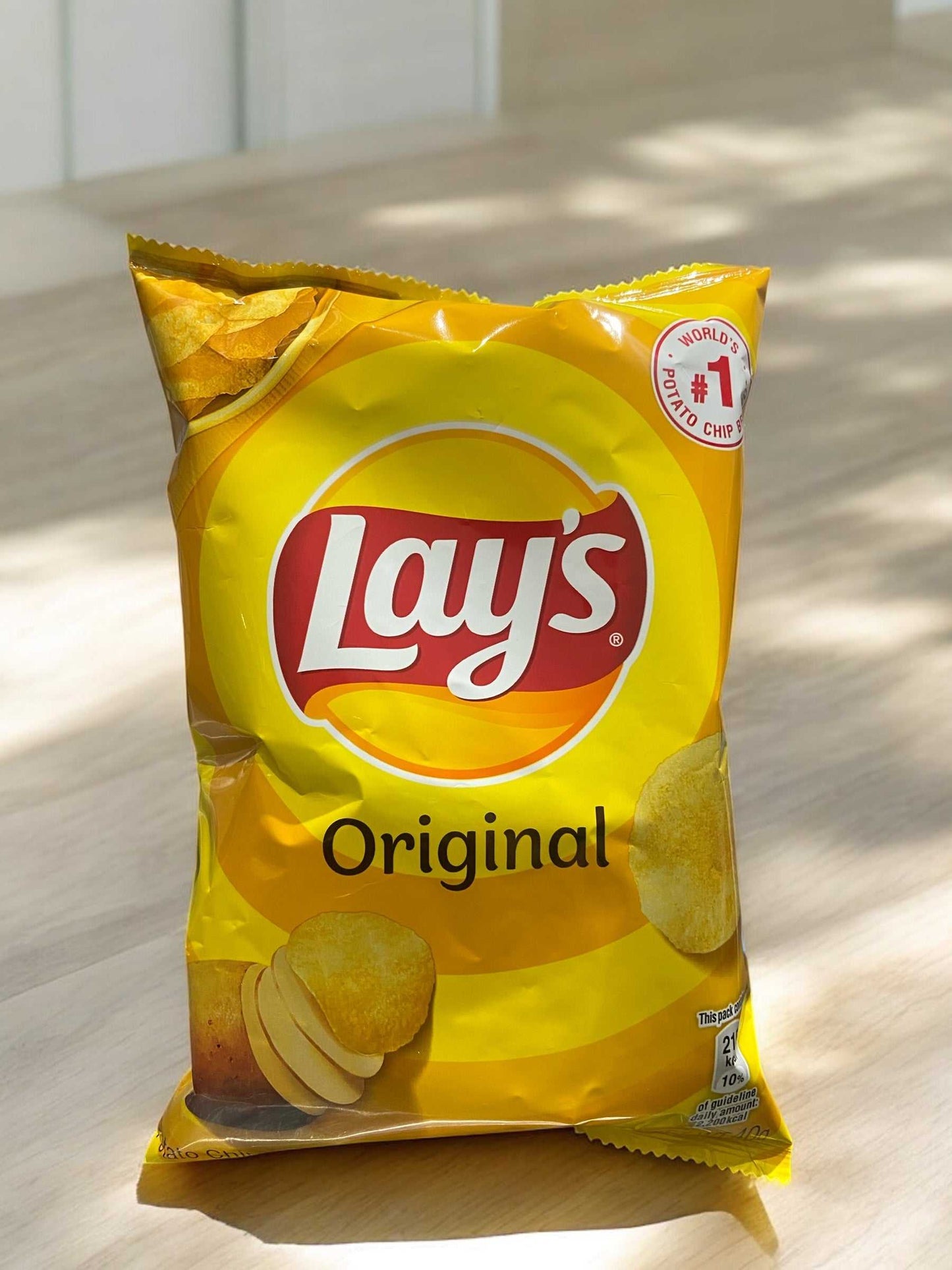 Lay's Original 40g potato chips bag with yellow packaging on a wooden surface