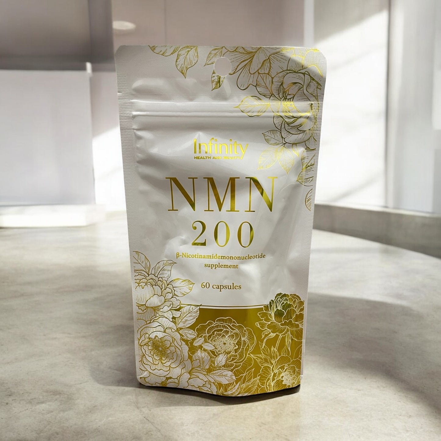 Infinity NMN 200 supplement pouch with 60 capsules, featuring decorative floral design.