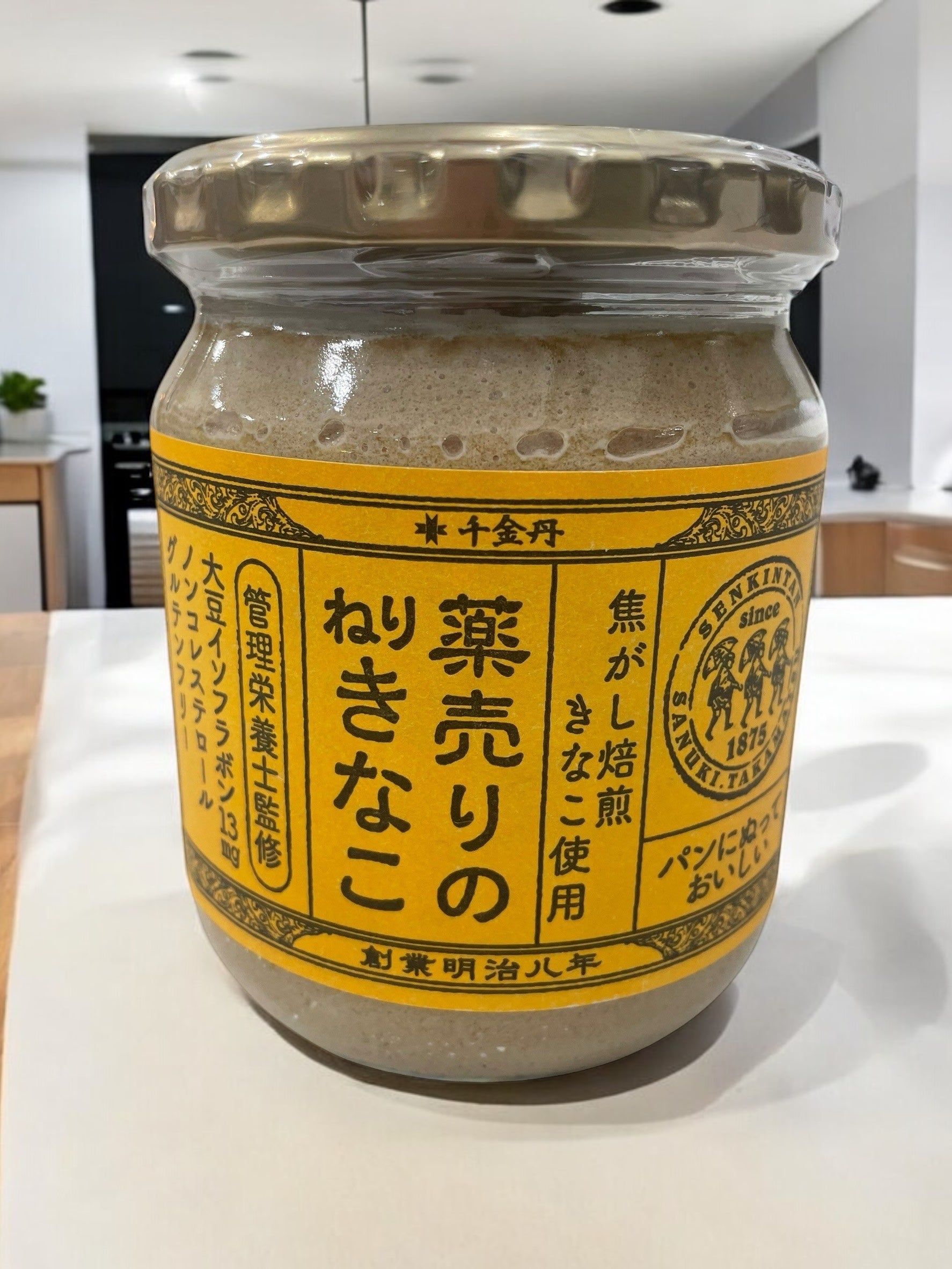 Retro-style jar of 千金丹薬売りのねりきなこ 380g with traditional illustration label.